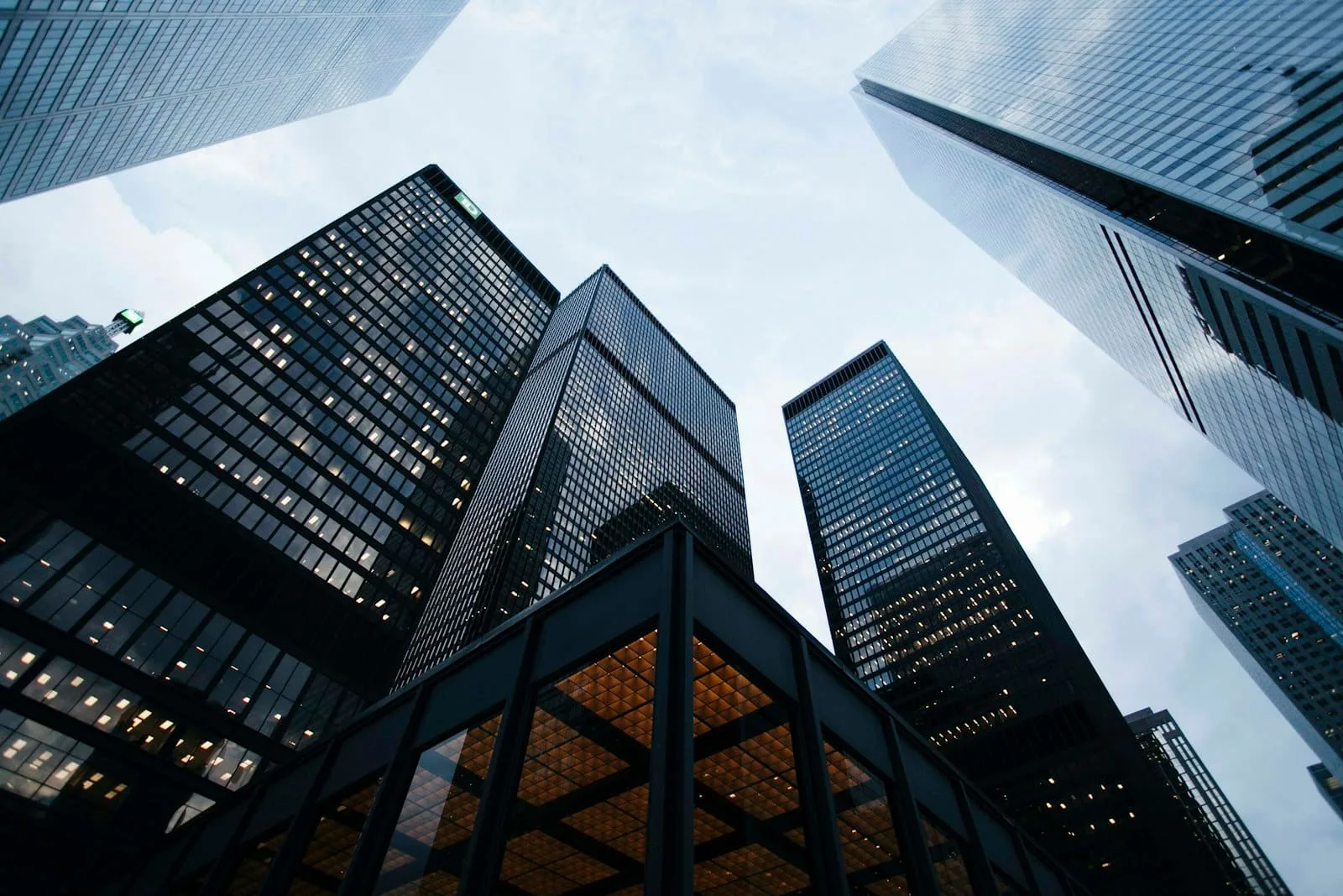 Glass office towers of a financial district seen from street level, looking up